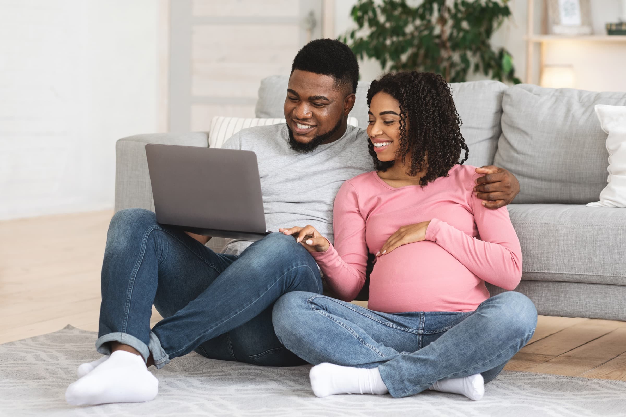 Couple sitting together at home using a laptop